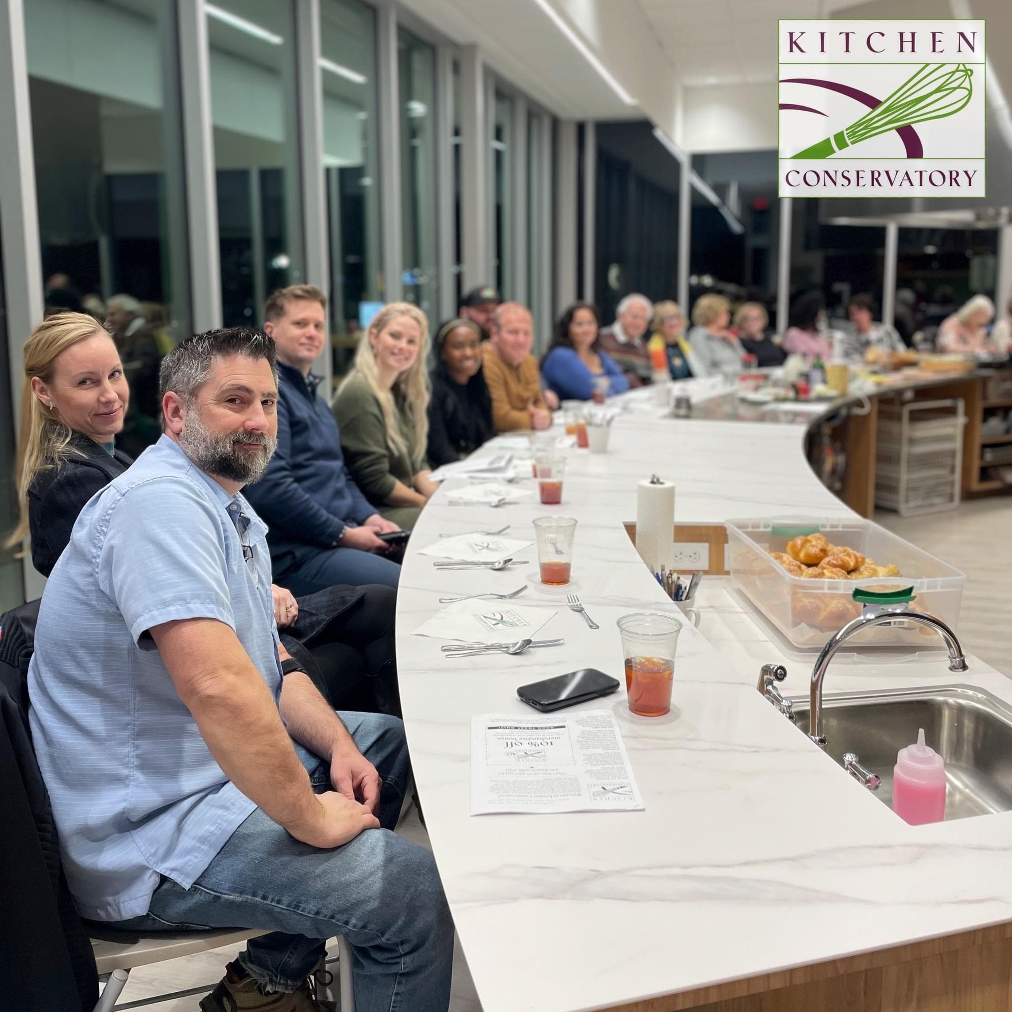 People gathered around a long table at a Habuyta cooking event at Kitchen Conservatory