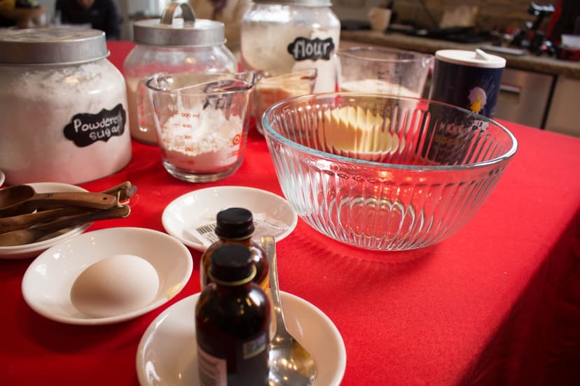Baking ingredients laid out on a red tablecloth — flour, butter, vanilla