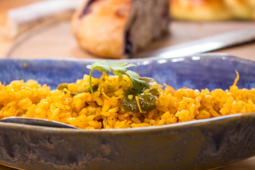Golden Mexican rice garnished with cilantro in a blue ceramic bowl